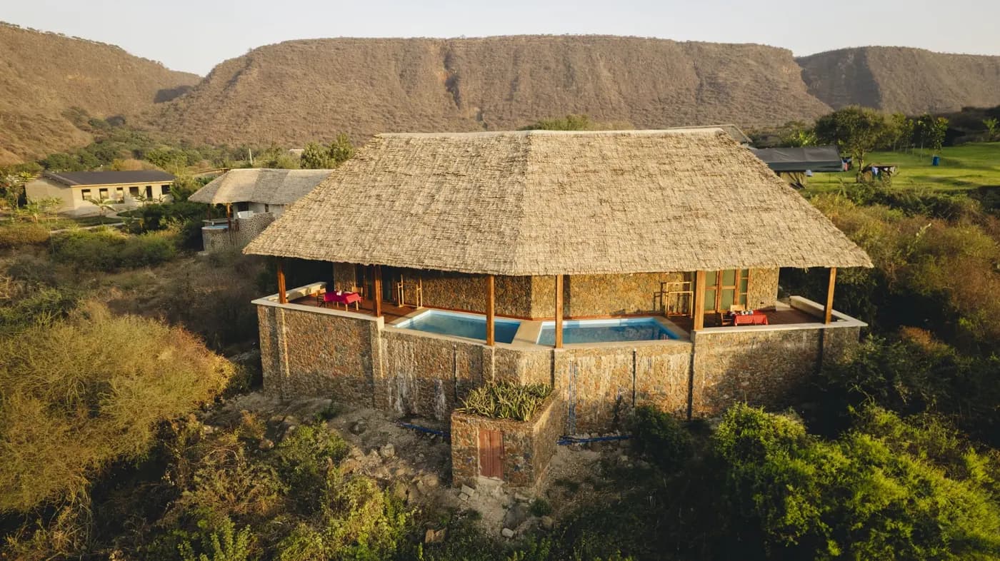 A thatched suite with its plunge pool from the air