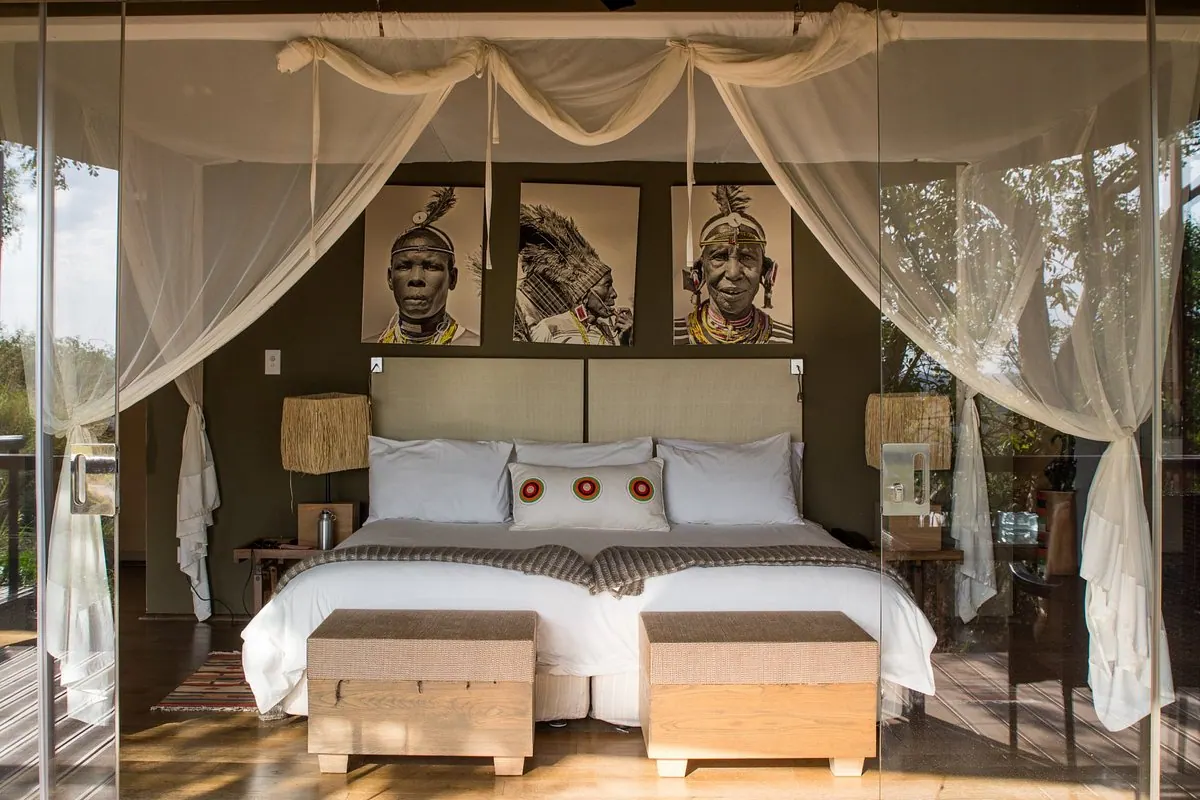 Twin beds below the portrait prints
