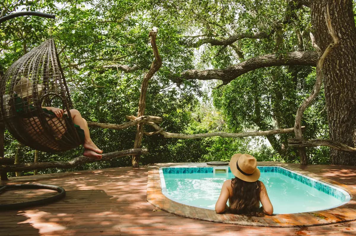 Pool deck with a hanging chair under the trees