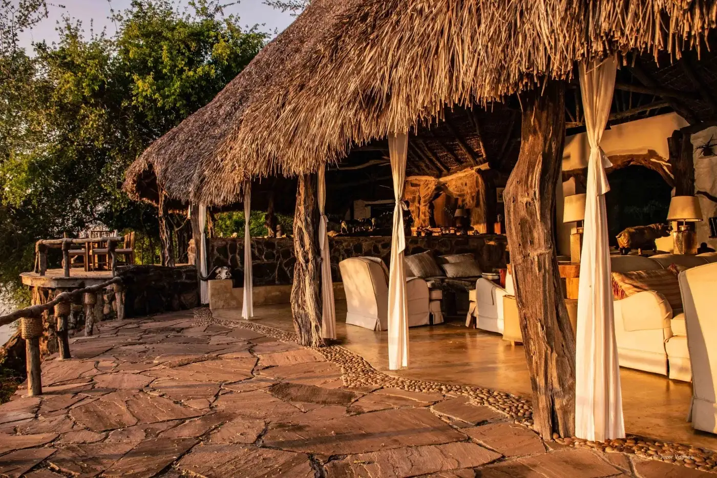 Thatched dining area with a stone floor