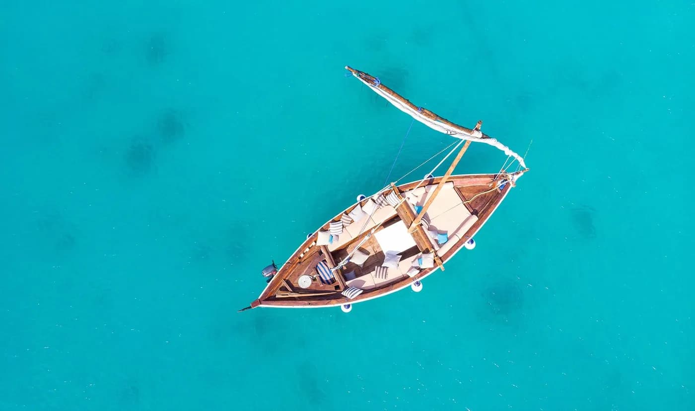 A dhow on the turquoise water from above