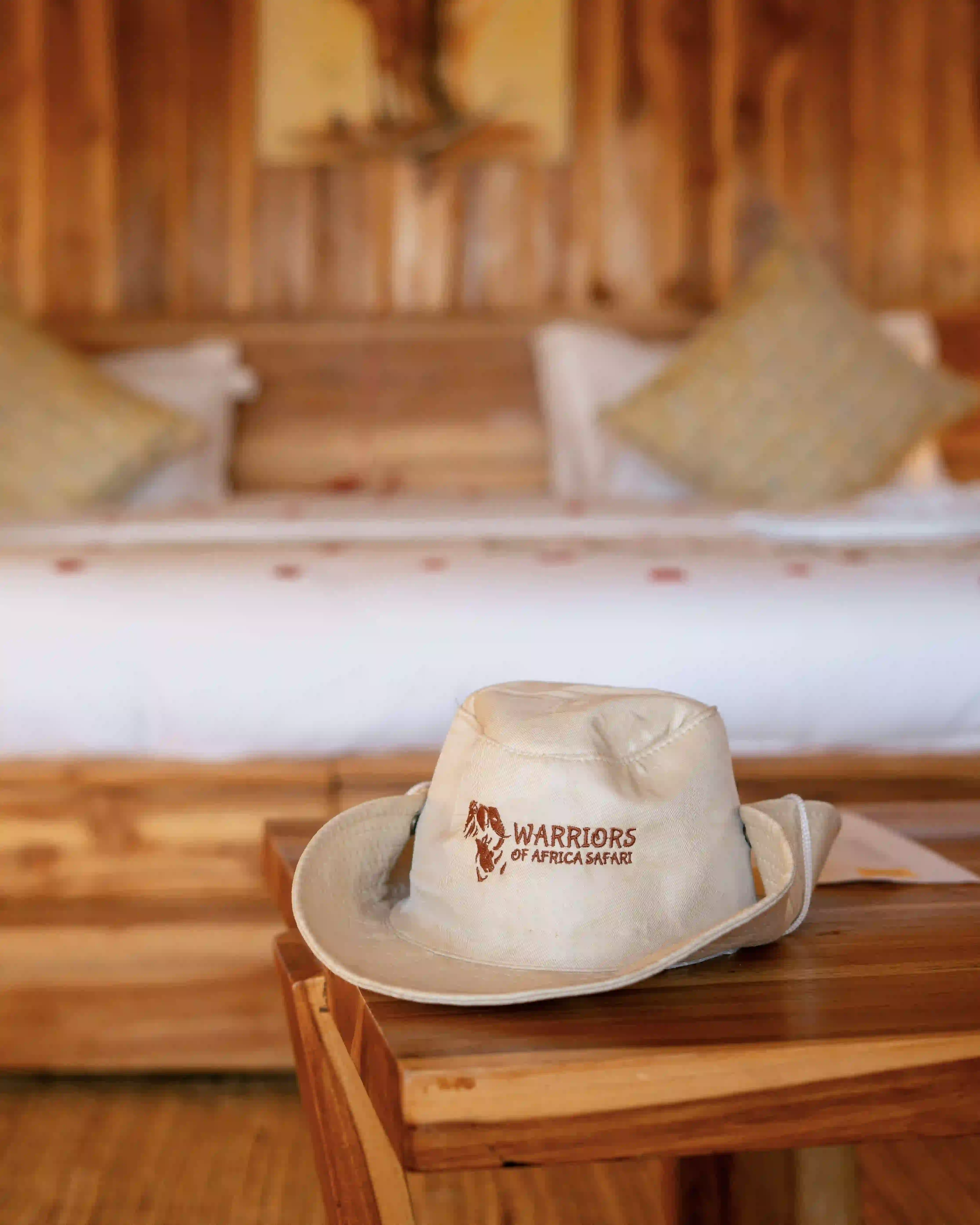 Branded safari hat resting on tented suite bed