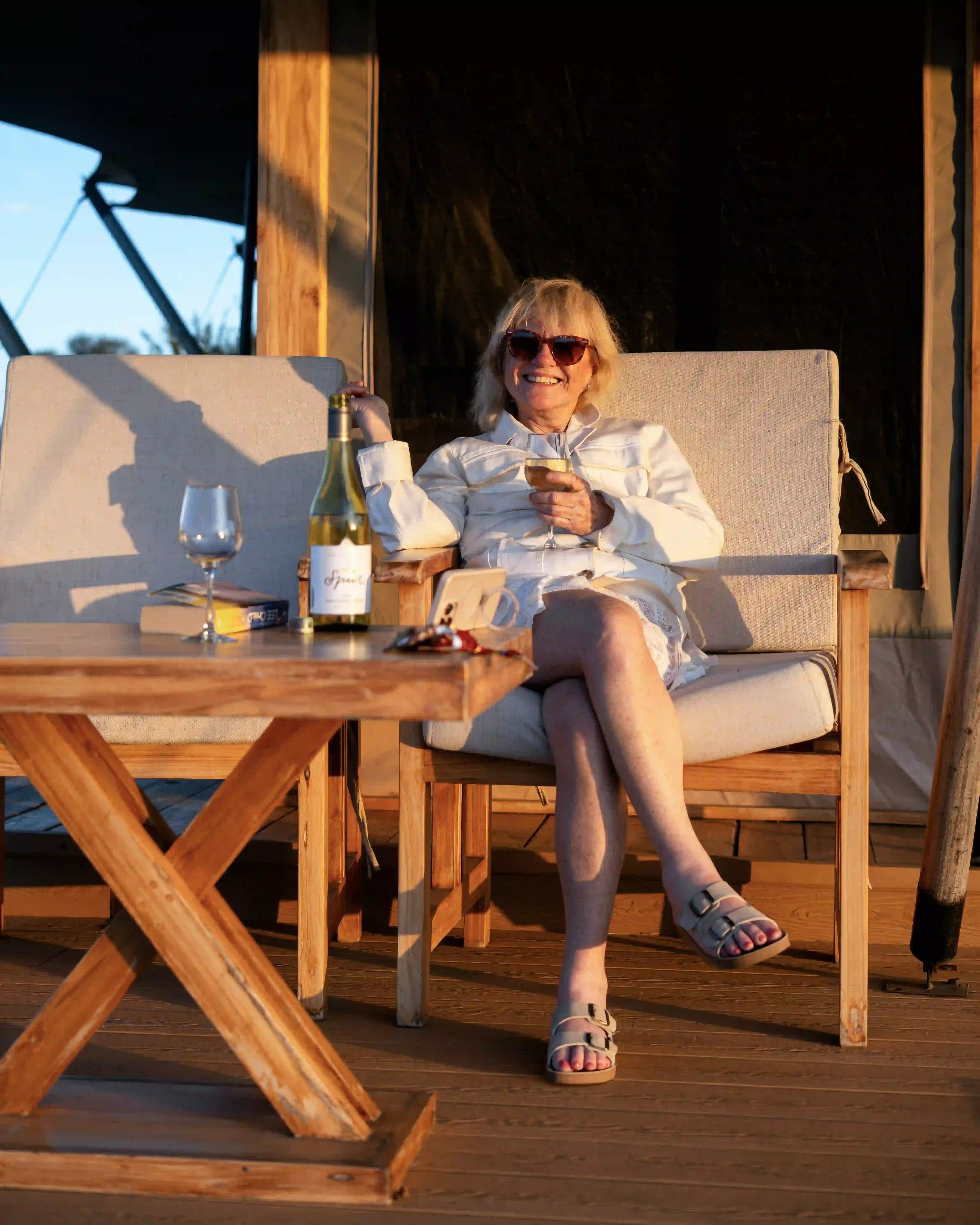 Woman relaxing on lodge deck with wine
