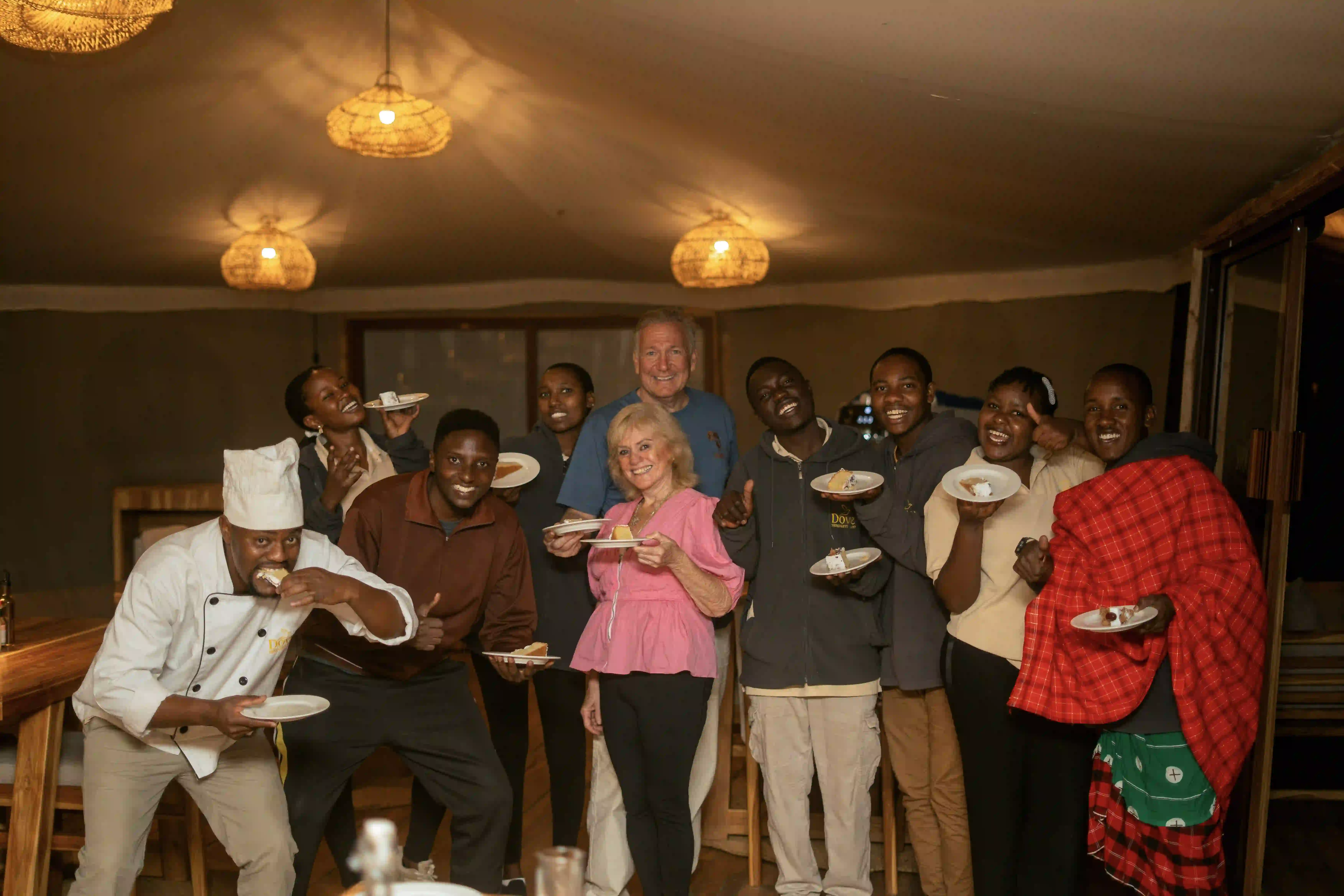 Large group photo celebrating with cake