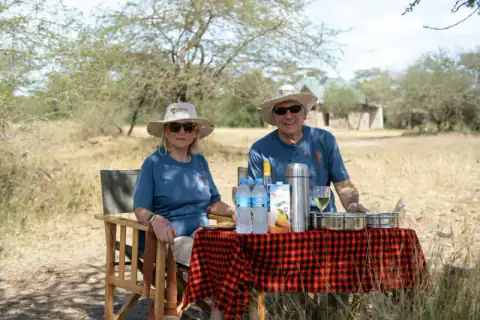 Couple in matching safari hats at picnic table