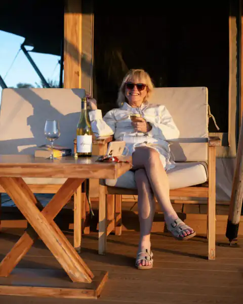 Woman relaxing on lodge deck with wine