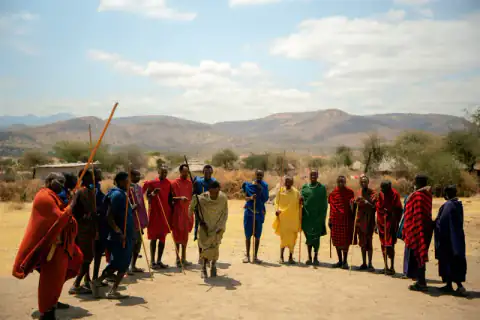 Maasai men lining up with staffs for a welcome song