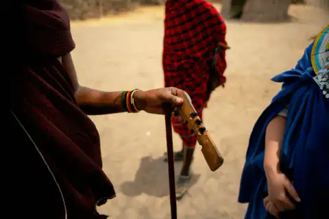 Close-up of a Maasai warrior's hands on a carved club