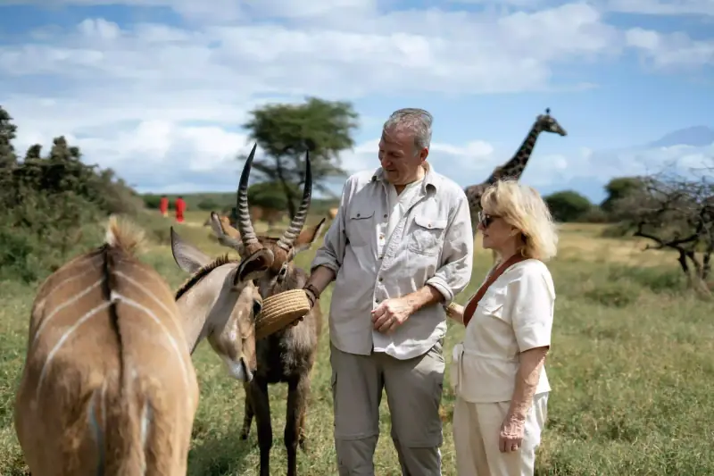 Couple with roan antelope and Maasai guides nearby