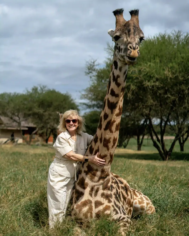 Woman hugging a giraffe's neck