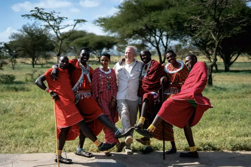 Man dancing playfully with Maasai warriors