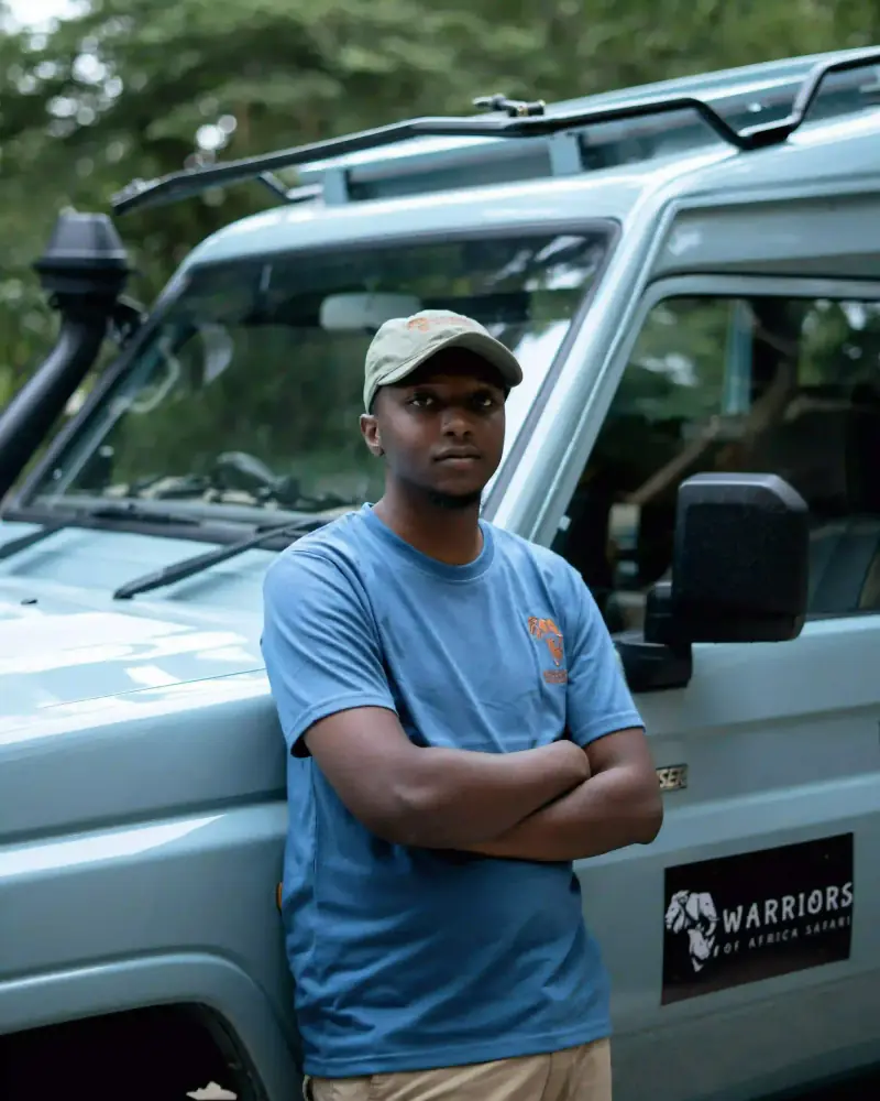 Staff member portrait beside safari vehicle