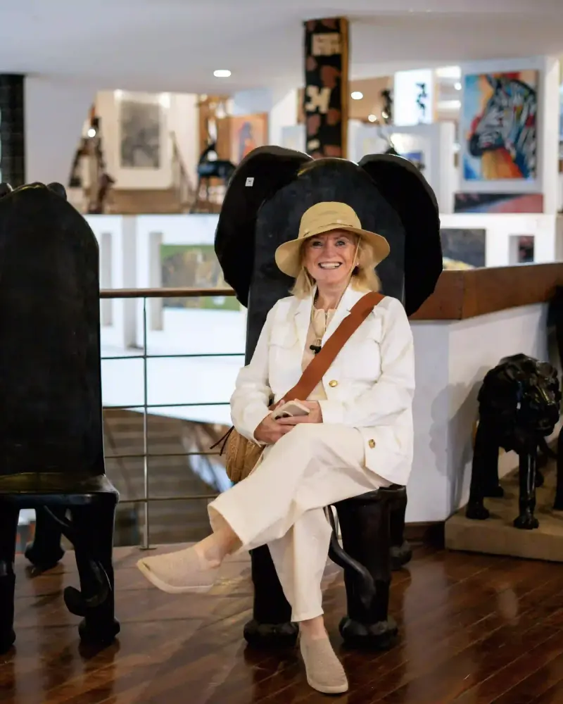 Woman seated in carved elephant-shaped chair