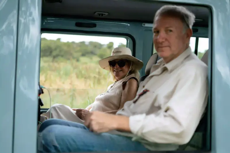 Couple sitting together inside safari vehicle