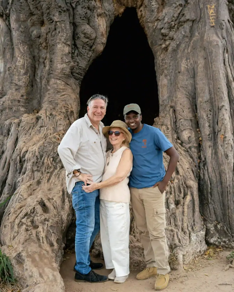 Guide and couple at giant baobab tree hollow