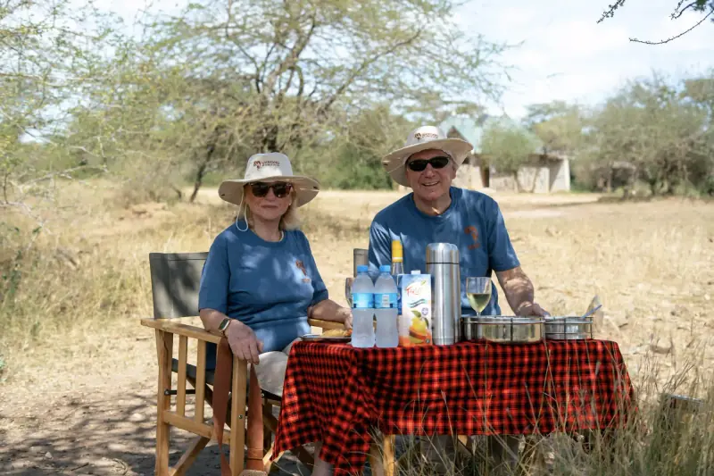 Couple in matching safari hats at picnic table