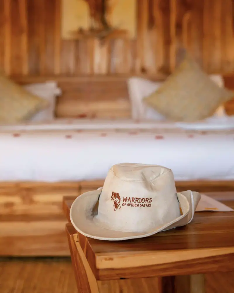 Branded safari hat resting on tented suite bed
