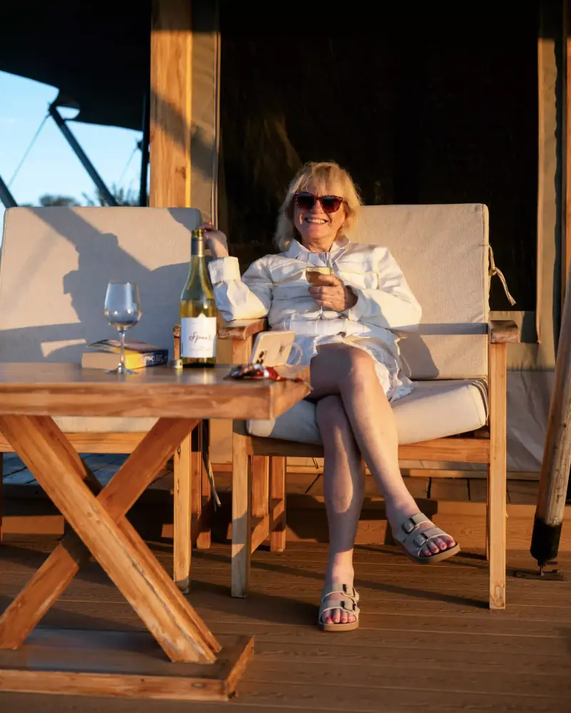 Woman relaxing on lodge deck with wine