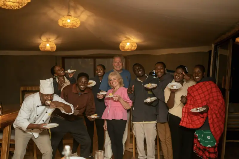 Large group photo celebrating with cake
