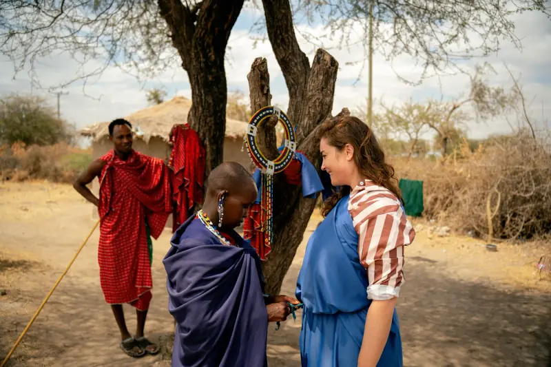 Maasai hosts greeting a guest outside their boma