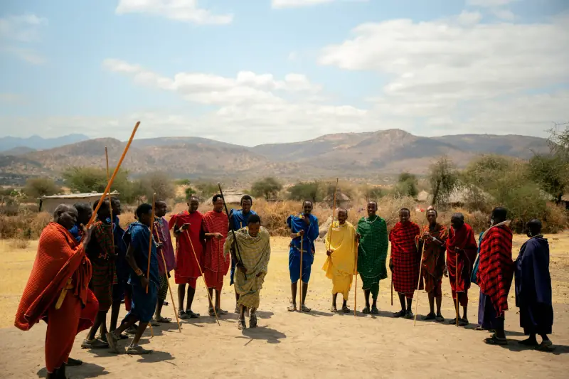 Maasai men lining up with staffs for a welcome song