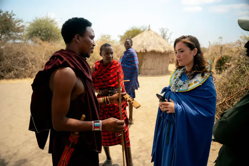 Conversation with Maasai men outside thatched huts