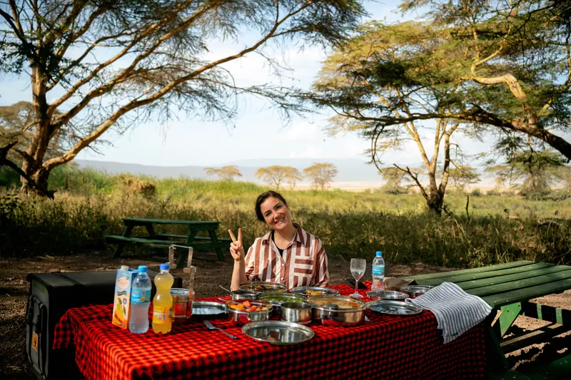 Bush lunch laid out on a red cloth under acacias