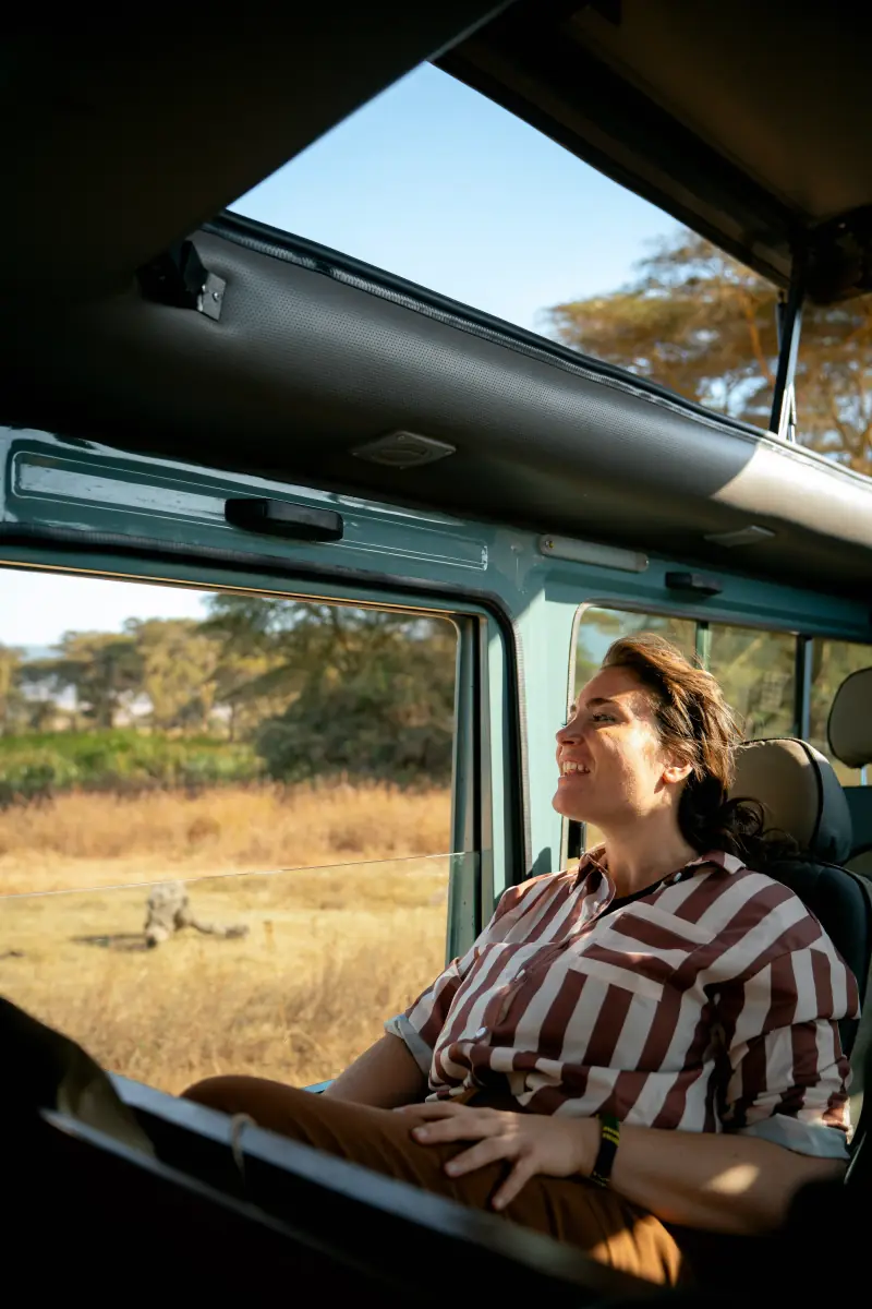 Guest smiling out of a vehicle window in golden light