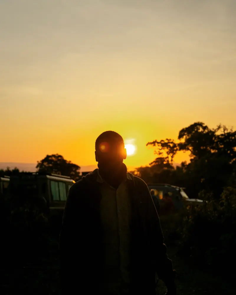 Guide silhouetted against a crater-rim sunrise