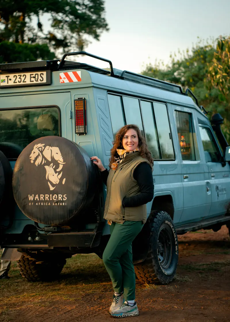 Guest beside the branded spare wheel at golden hour