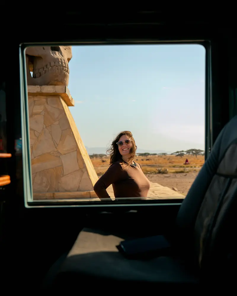 Guest posing in the vehicle window by the gate monument