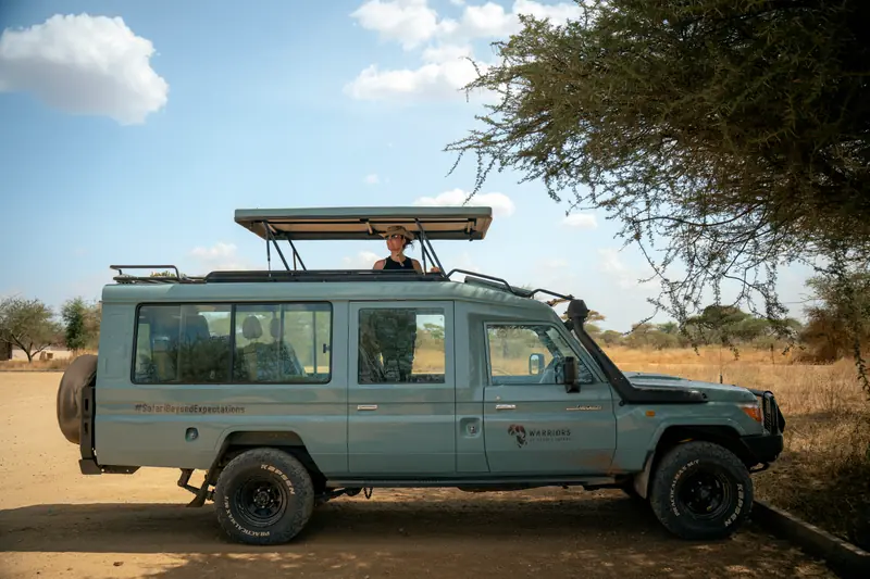 Warriors of Africa vehicle parked under an acacia