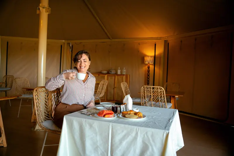 Raising a cup of coffee over breakfast in the tent