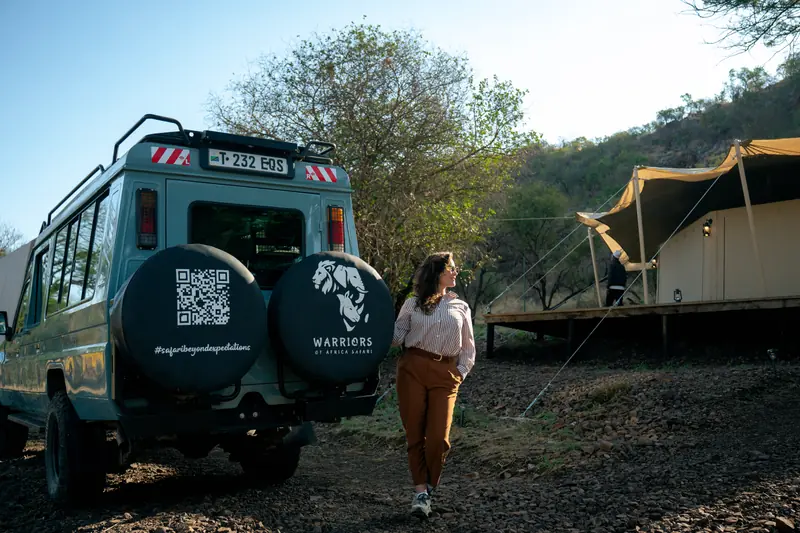 Walking back past the vehicle toward the tents