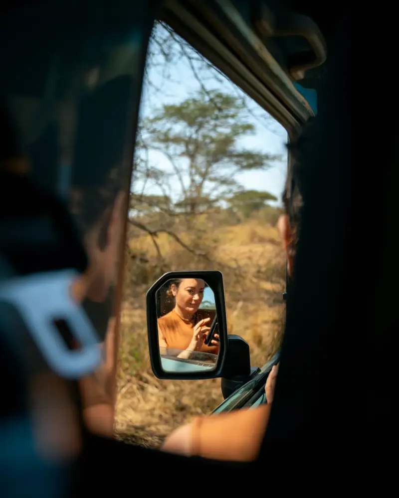 Guest's reflection in the safari vehicle wing mirror
