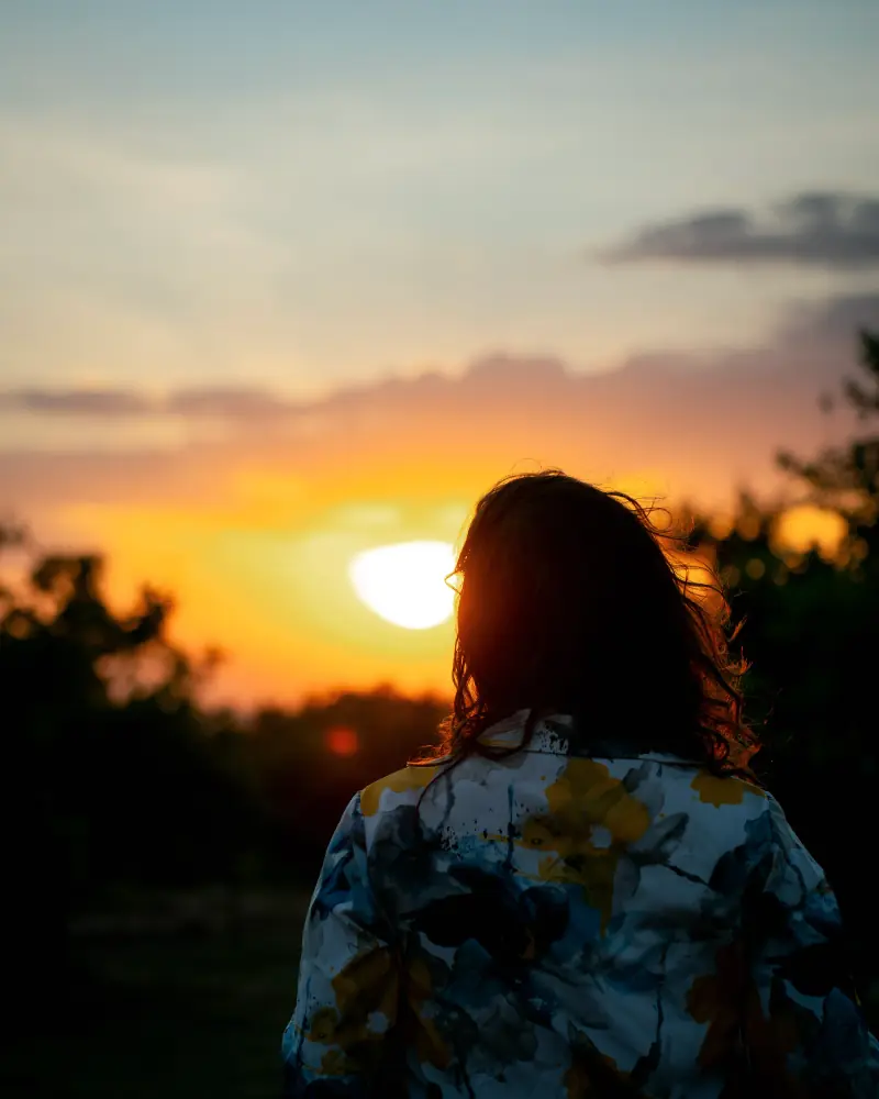 Guest watching the sun drop behind the treeline