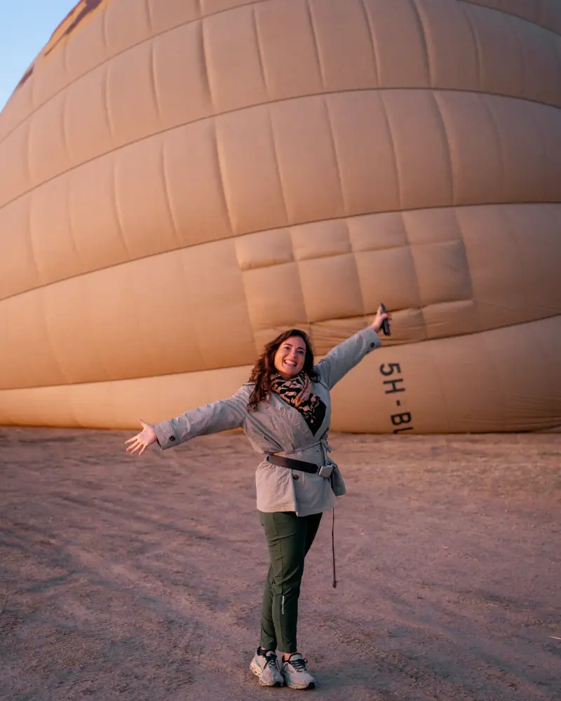 Guest with arms wide beside an inflating balloon
