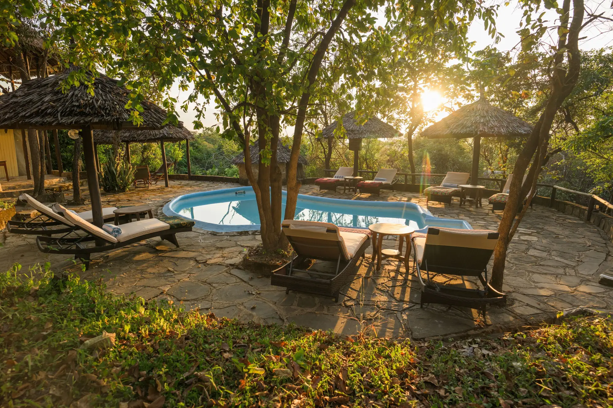 Pool among the thatched shade at sunset